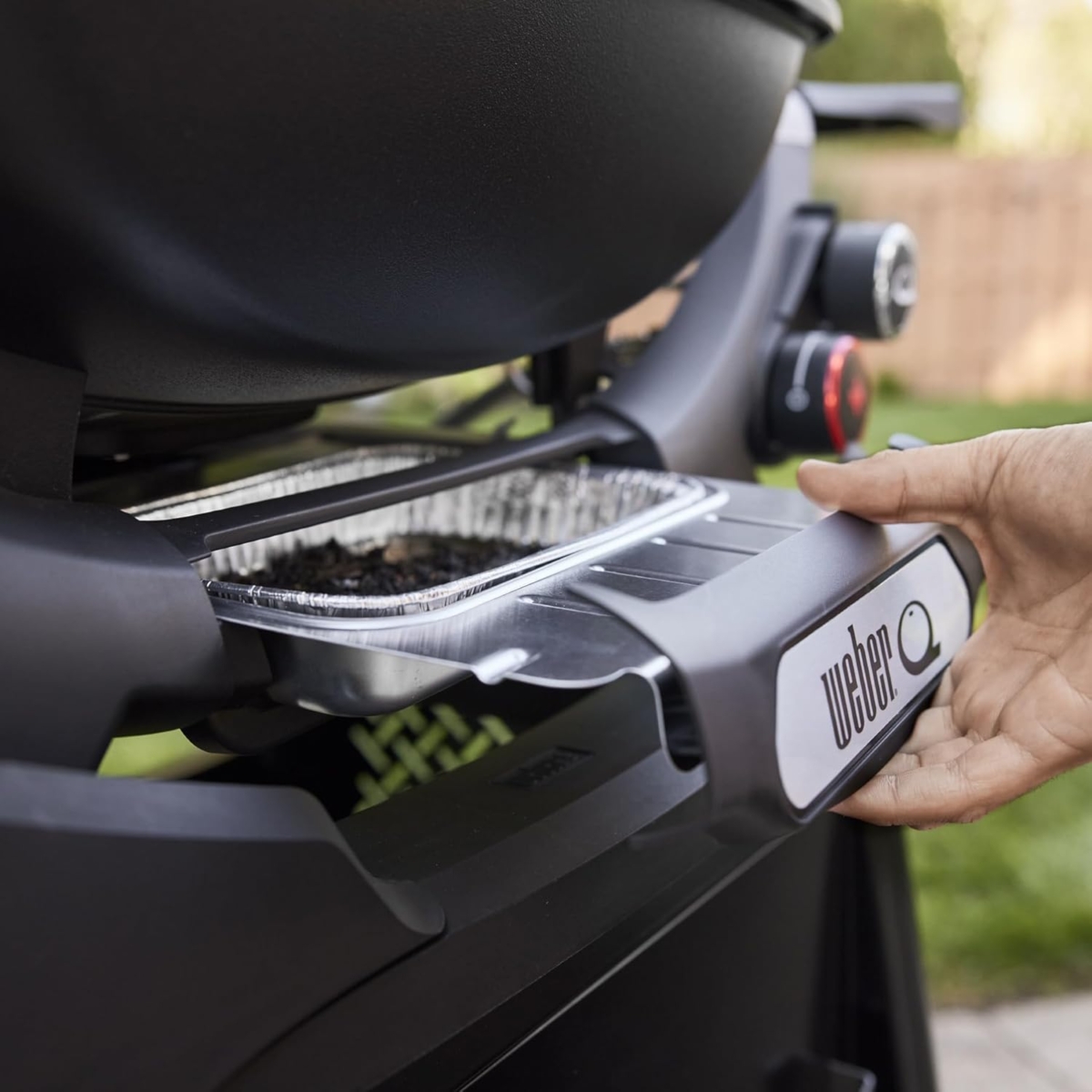 Parrilla Weber con bandeja ajustable al aire libre.