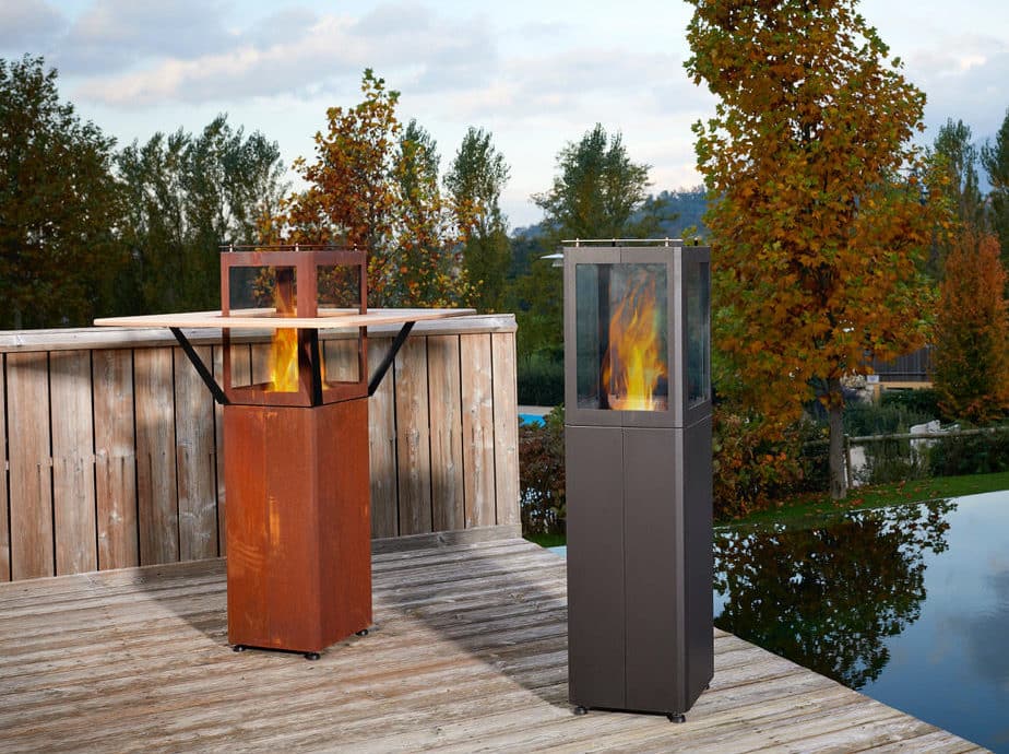 Chimeneas exteriores encendidas en terraza de madera