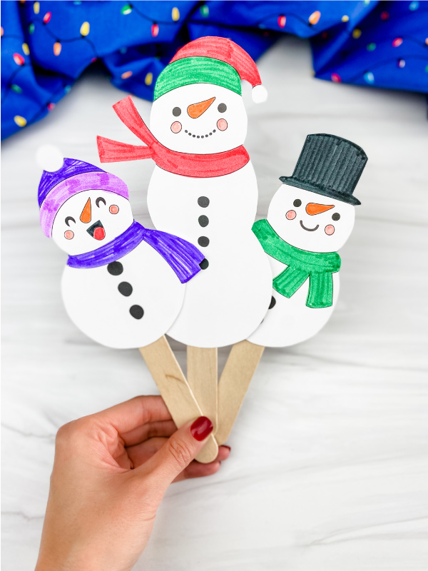Muñecos de nieve en palitos con bufandas coloridas.