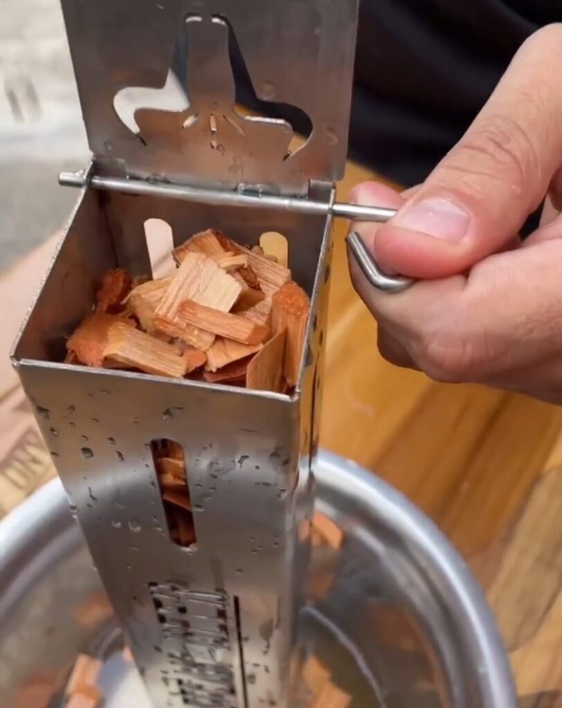 Llenando caja metálica con astillas de madera.