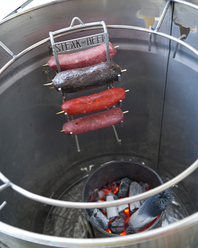 Parrilla de salchichas sobre brasas humeantes