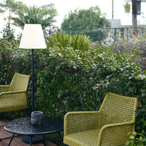 Terraza con sillones verdes y mesa redonda